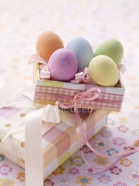 Closeup view of an Easter parcel with brightly colored eggs and a present — Stock Photo