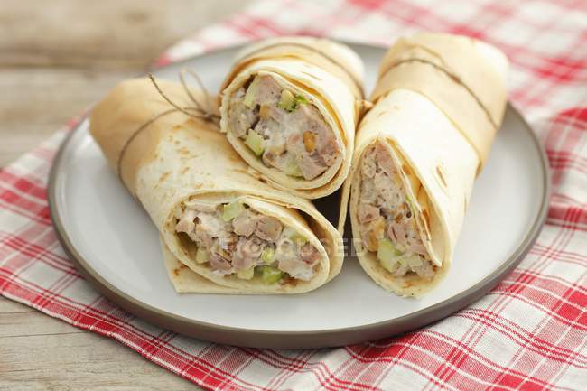 Wraps filled with chicken and celery salad  on white plate over towel — Stock Photo
