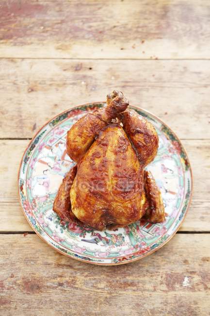 Whole roasted chicken on ceramic dish — Stock Photo