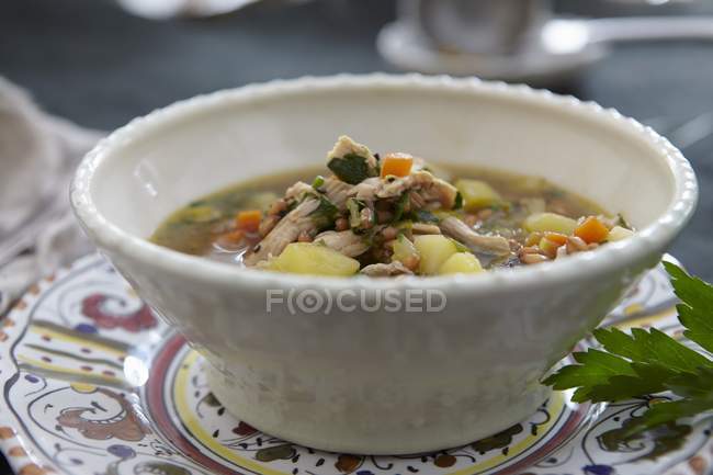 Chicken soup with barley and vegetables in white bowl — Stock Photo