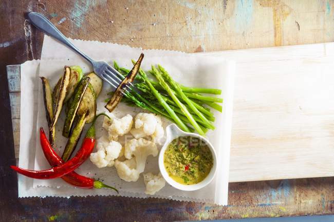 Gedünstetes Gemüse mit Curry-Dip über Holztisch — Stockfoto