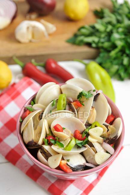 Shellfish with chilli, garlic and parsley in bowl over towel — Stock Photo
