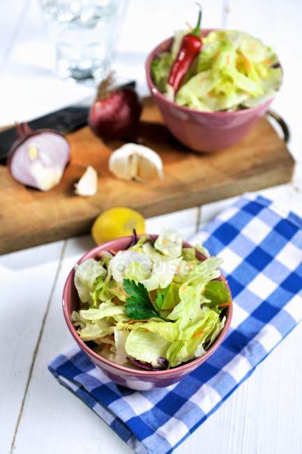 Mixed salad on wooden desk over towel — Stock Photo