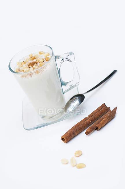 Vista de cerca de Sahlab con leche caliente, cacahuetes y palitos de canela - foto de stock