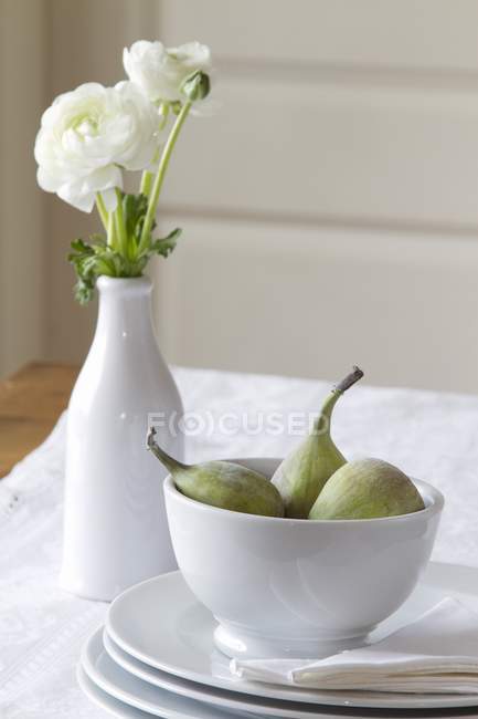 Ranúnculo branco e tigela de figos doces — Fotografia de Stock