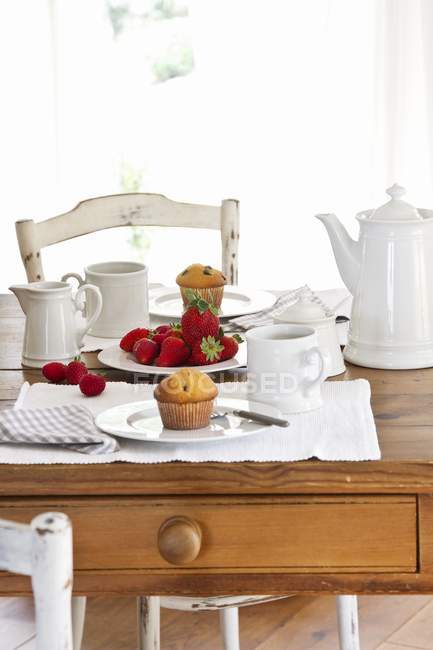 Mesa colocada para café com muffins — Fotografia de Stock