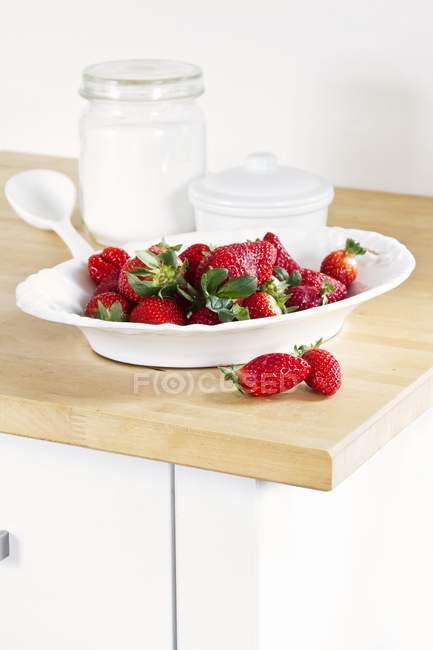 Fresh strawberries in white bowl — Stock Photo