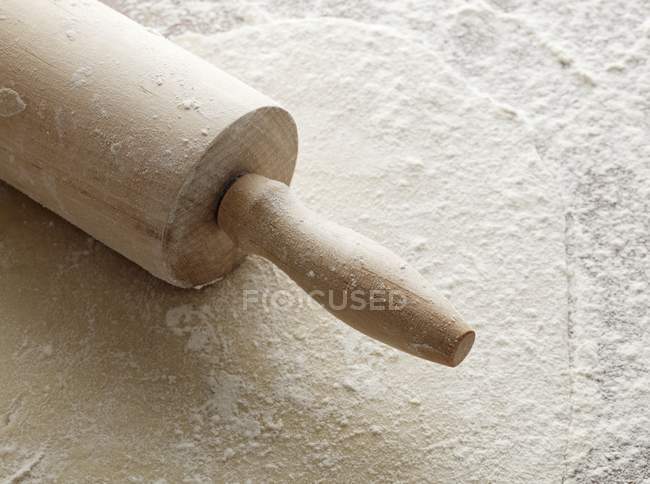 Closeup view of rolled-out pastry with a rolling pin and flour — Stock Photo