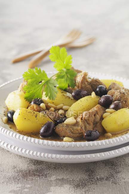 Крупный план баранины Тагин с картофелем, оливками и кедровыми орехами — стоковое фото