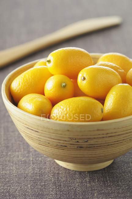 Kumquats frescos en tazón - foto de stock