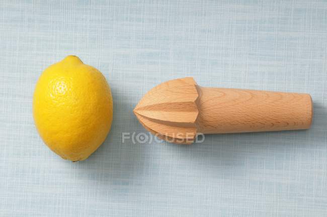 Limón fresco y exprimidor de madera - foto de stock