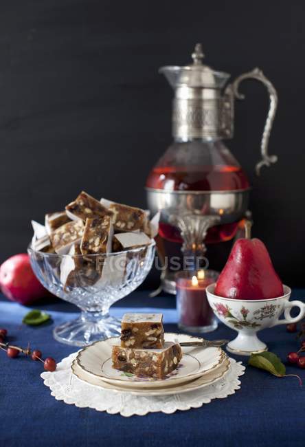 Closeup view of Panforte squares with a pear and candle — Stock Photo