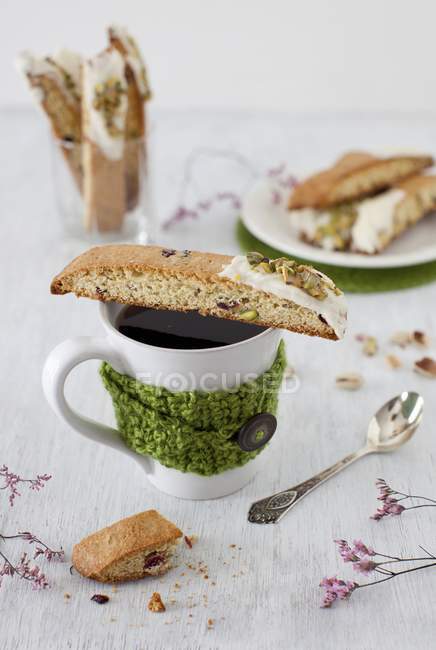 Closeup view of orange Biscotti with pistachios on a cup of coffee — Stock Photo