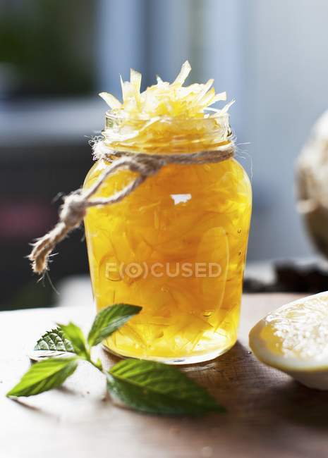 Scorza di limone candita in un barattolo su una superficie di legno — Foto stock