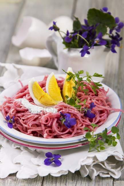 Beetroot linguine pasta with boiled eggs — Stock Photo