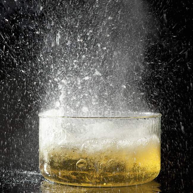 Closeup view of an explosion of oil after adding an ice cube — Stock Photo