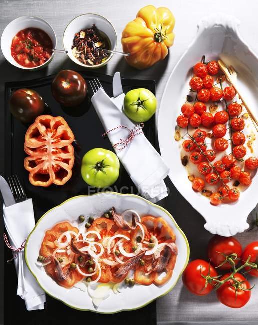 Piatti di pomodoro assortiti e pomodori freschi — Foto stock
