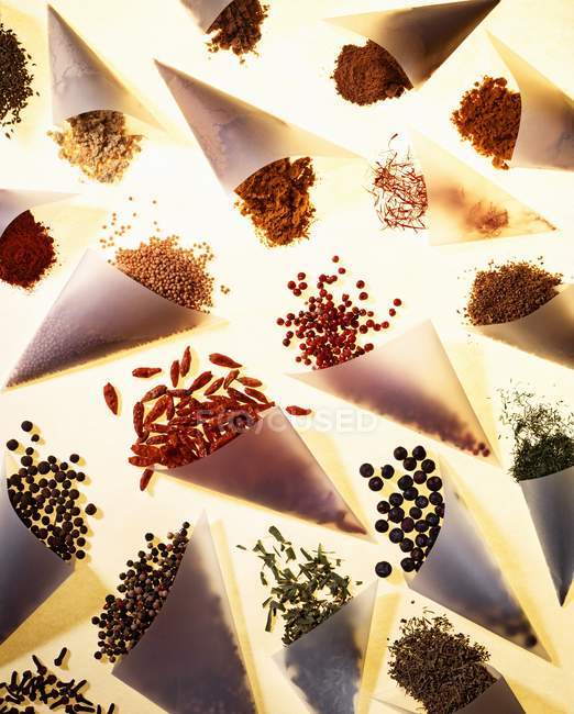 Assorted spices in baking parchment cones — Stock Photo