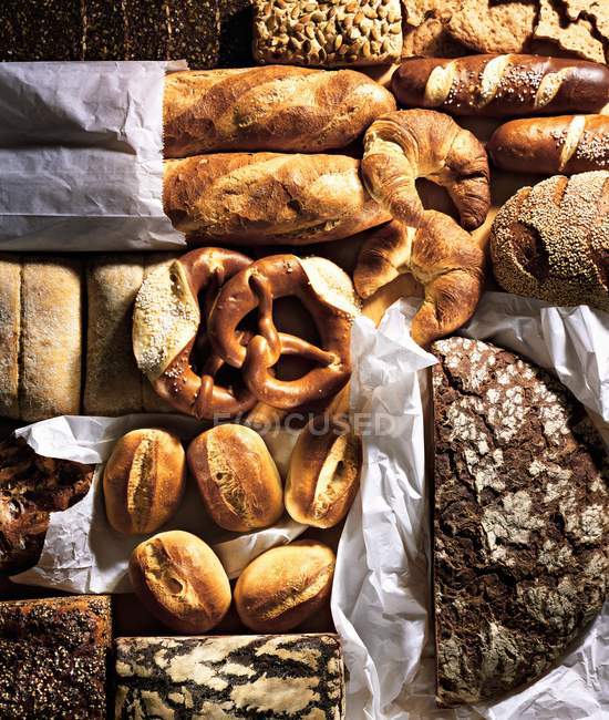 Assorted breads on baking parchment — Stock Photo