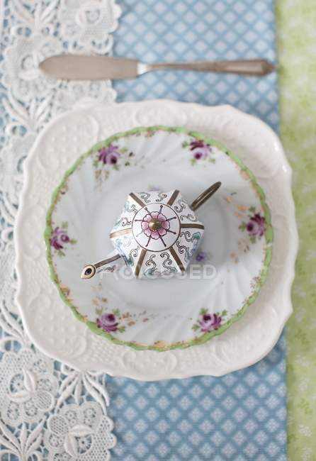 Elevated view of decorative tea pot on plates — Stock Photo