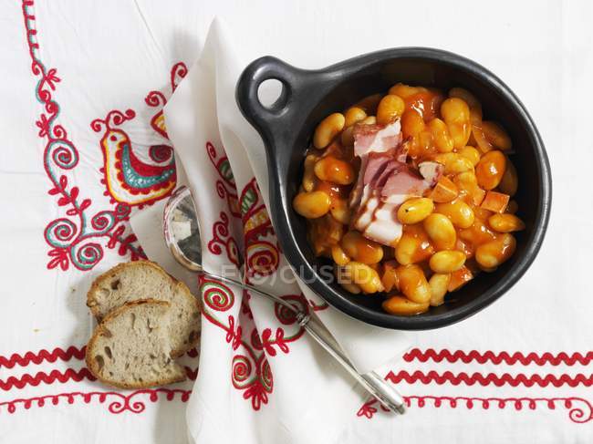 Fasolka po bretonsku - bean stew in black bowl over tablecloth — Stock Photo