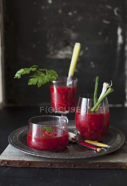 Summer borscht in glasses over black plate — Stock Photo