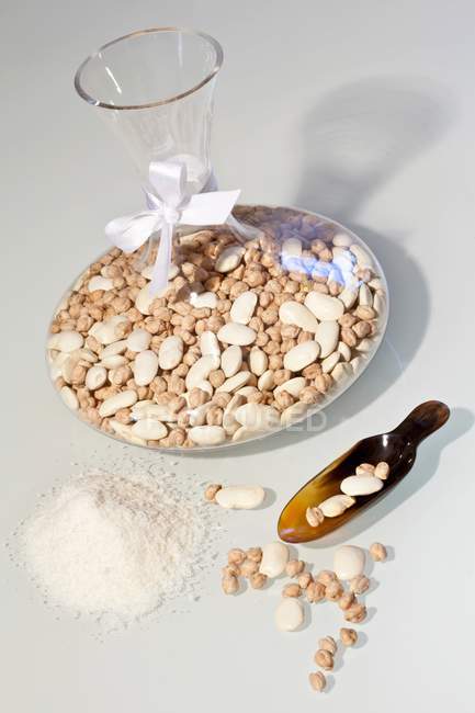 Getrocknete Bohnen und Kichererbsen in einer Karaffe als Geschenk auf weißer Oberfläche — Stockfoto