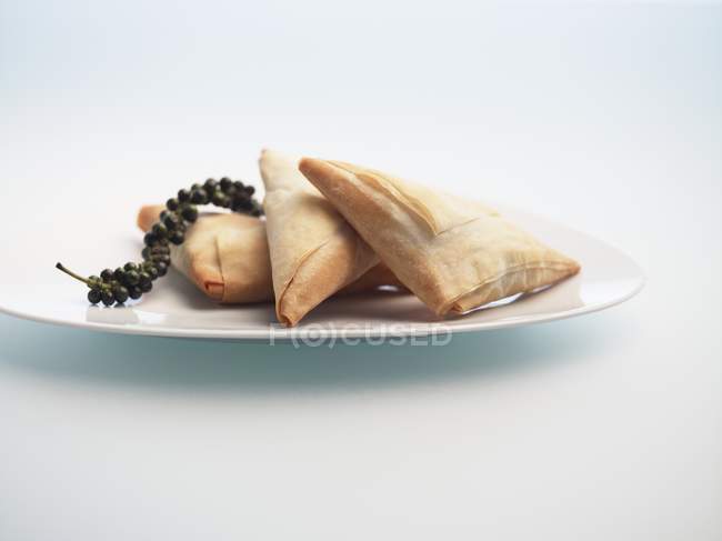 Closeup view of Briouats filled pastry parcels on white dish — Stock Photo
