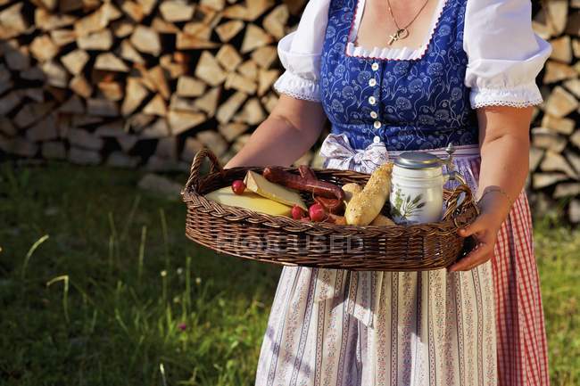 Daytime cropped view of woman wearing dirndl and carrying tray with meal — Stock Photo