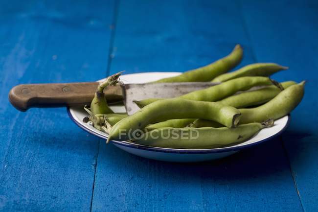Broad haricots frais dans un bol avec couteau — Photo de stock