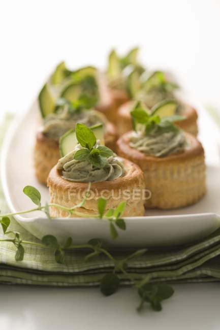 Vol-au-vents riempito con zucchine e pasta di erbe su piatto bianco — Foto stock