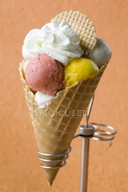 Fruit ice cream with cream in a wafer cone — Stock Photo