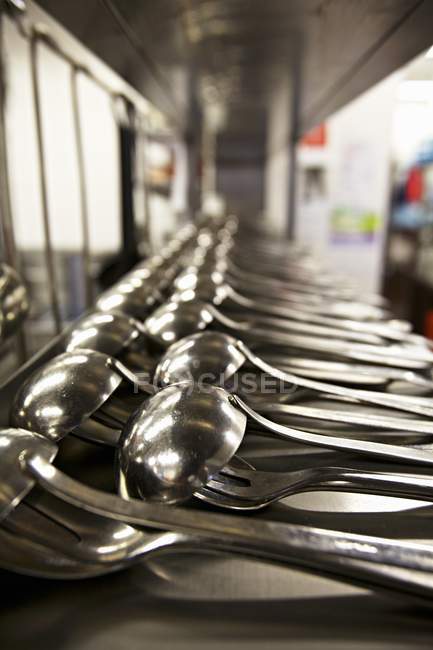 Closeup view of ladles with forks and spoons in rows — Stock Photo