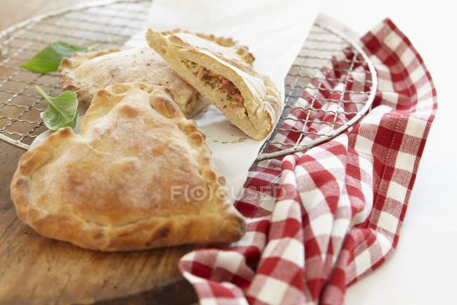 Closeup view of whole and halved heart-shaped Calzone on cooling rack — Stock Photo