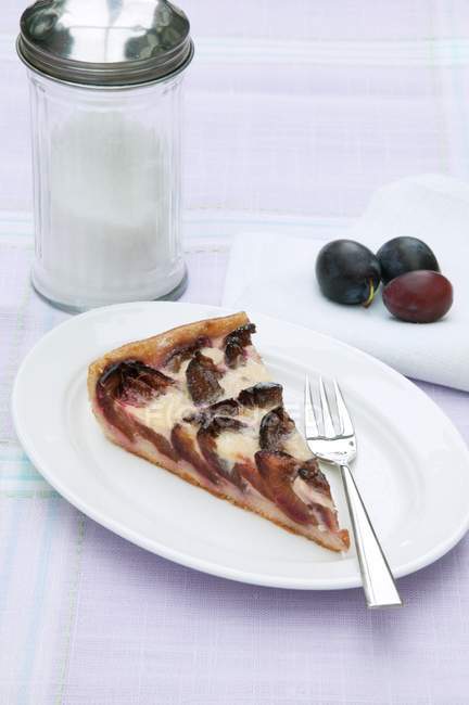 Cheesecake with plums on plate — Stock Photo