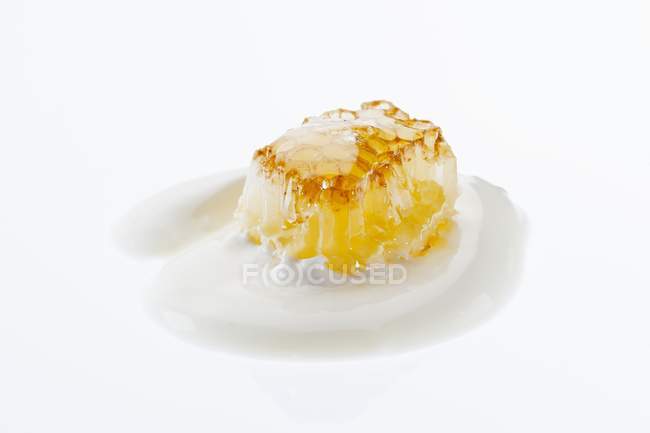 Honeycomb with yoghurt on white — Stock Photo
