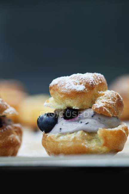 Closeup view of profiterole filled with quark and blueberries — Stock Photo
