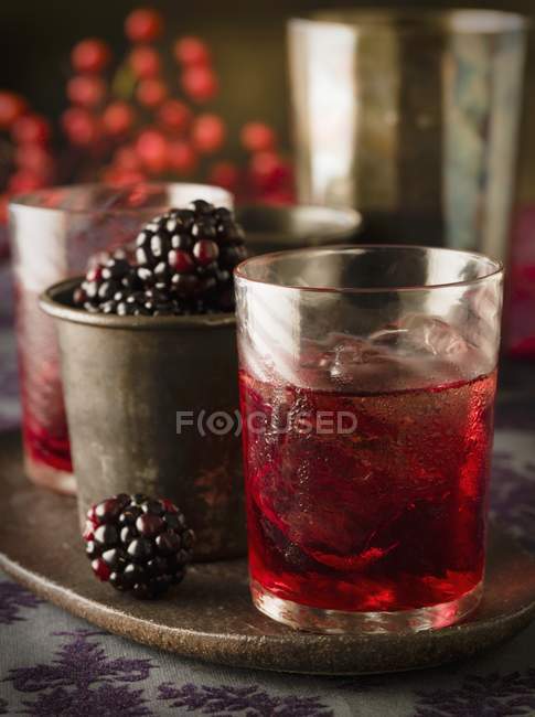 Closeup view of blackberries with liqueur and ice cubes — Stock Photo
