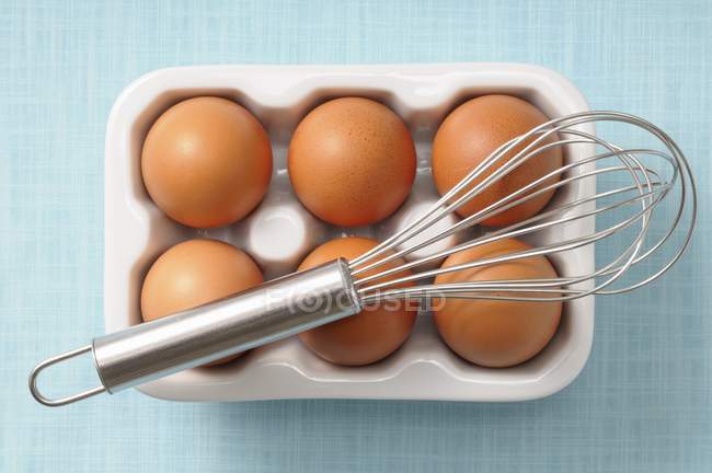 Brown eggs in porcelain egg box — Stock Photo
