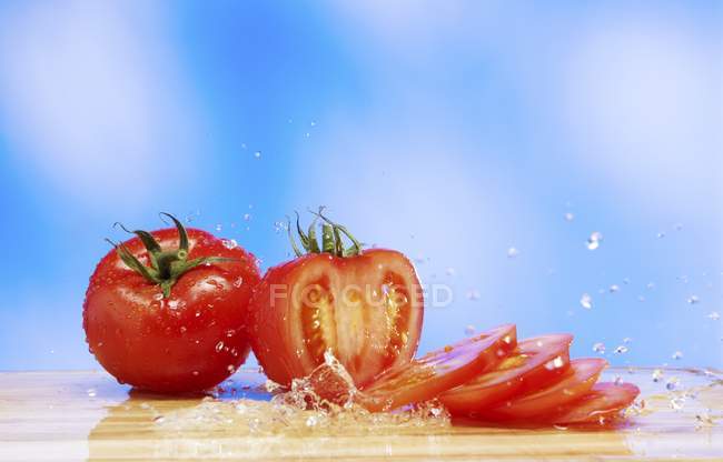 Tomates avec éclaboussure d'eau — Photo de stock