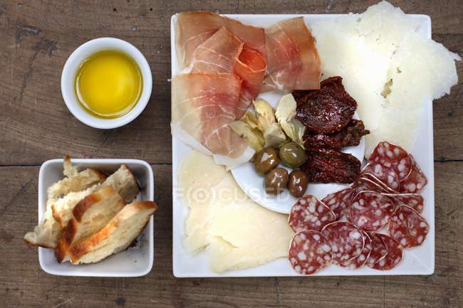 Antipasti on plate and bowls — Stock Photo