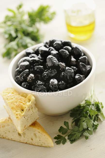 Olive nere con erbe aromatiche in ciotola — Foto stock