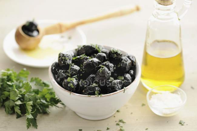 Black olives with herbs in bowl — Stock Photo