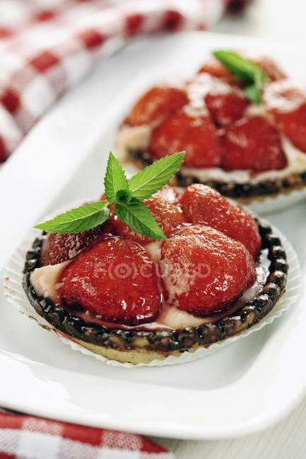 Strawberry tarts with mint leaves — Stock Photo