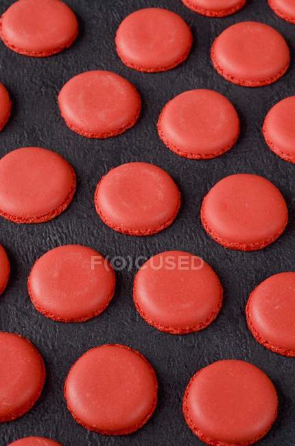 Freshly baked red macaroon halves — Stock Photo