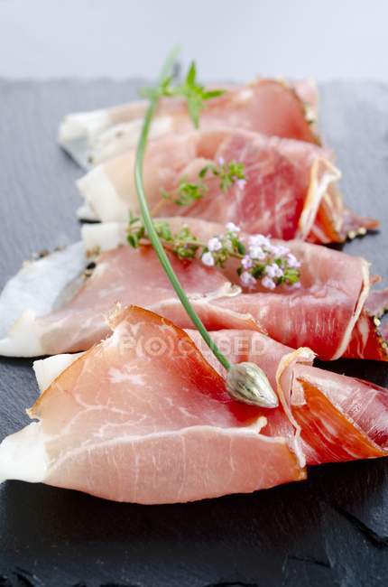Slices of Black Forest ham with herbs — Stock Photo