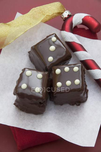 Quadrados de chocolate sobre papel — Fotografia de Stock