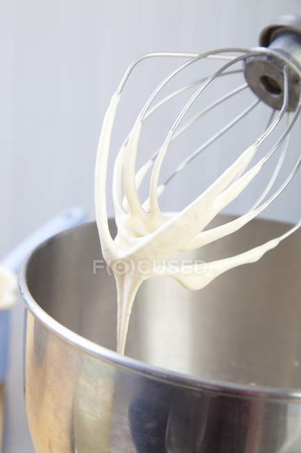 Closeup view of an egg whisk on a food processor with remnants of beaten egg white — Stock Photo