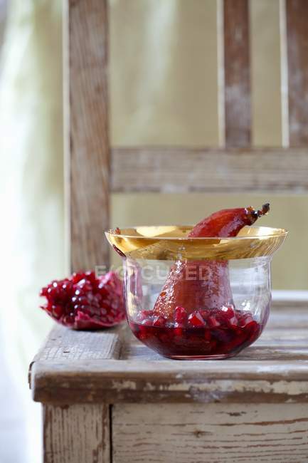 Closeup view of pear poached in red wine with pomegranate — Stock Photo