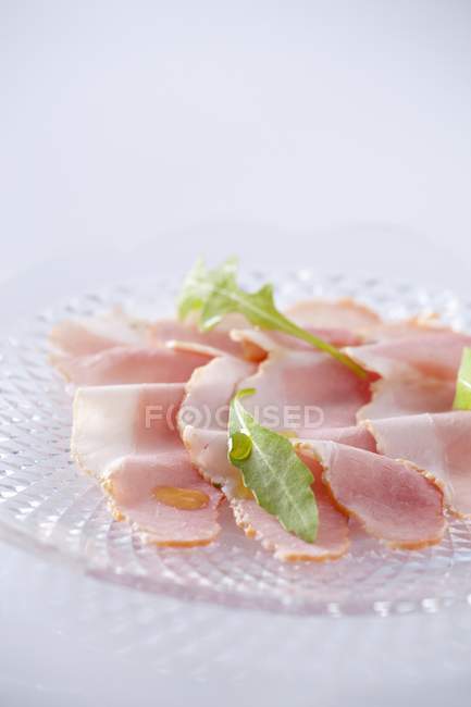Sliced ham and rocket leaves — Stock Photo